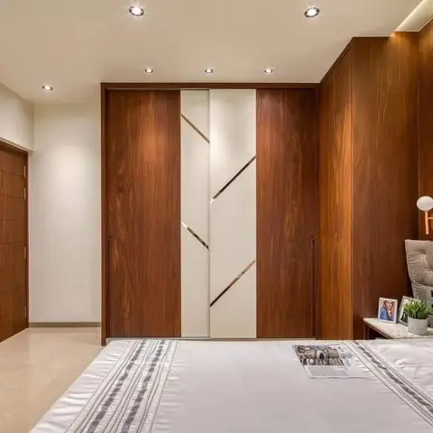 A bedroom wardrobe wall with diagonal brass inlay strips across walnut and white sliding panels
