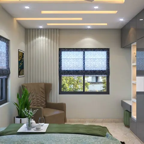 A bedroom with a green tufted bed runner, a leather wingback chair by a floral roman-blind window, and a glossy grey wardrobe beside a lit display shelf.