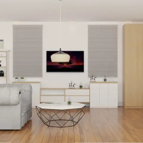 A bedroom with a light-oak wardrobe and TV console, a tufted grey chesterfield-style lounge chair, a geometric wire-frame coffee table
