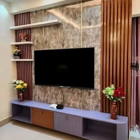 A brown marble-effect TV wall bordered by vertical wood fluted panels sits above a curved lavender console with mixed wood and fluted shutters.