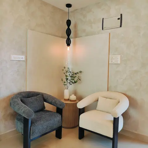 A corner seating nook with two boucle armchairs in grey and cream facing each other