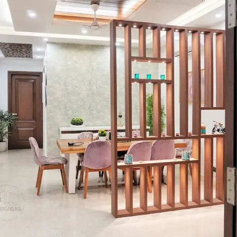 A dining area framed through the entrance foyer, screened by a vertical wood-slat room divider with display niches