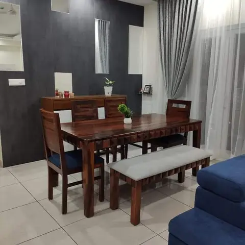 A dining nook with a dark textured feature wall inset with narrow mirror strips, a solid sheesham wood dining table with a bench and navy-cushioned chairs