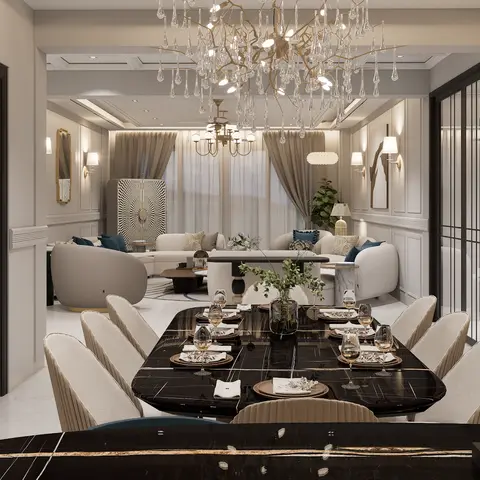 A dining room with a book-matched black marble table set for eight beneath an oversized crystal branch chandelier, wainscoted walls