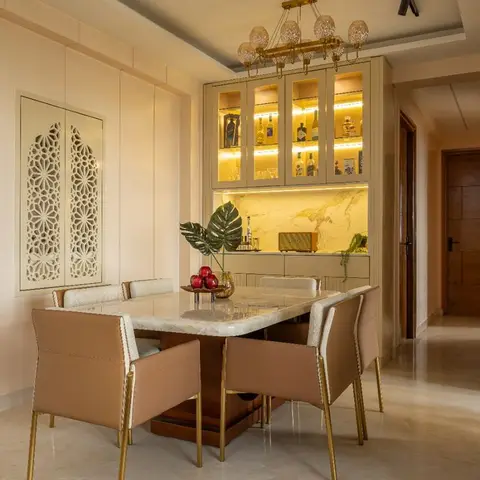 A dining room with a marble-top table on a brass-trimmed base, tan leather-and-cane chairs