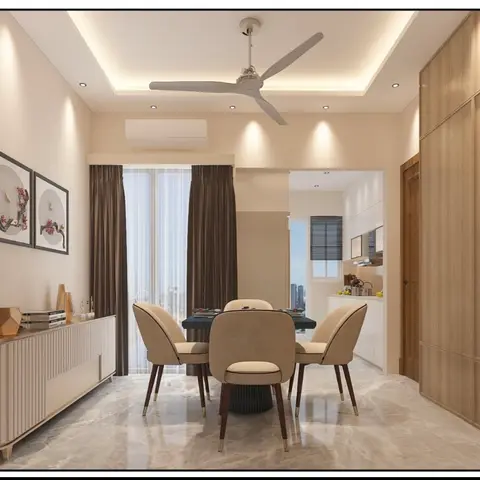 A dining room with a round beige upholstered dining set on marble flooring, a ceiling fan set into a cove-lit pop ceiling