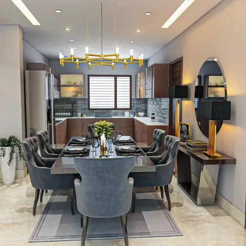 A dining room with tufted grey velvet chairs around a marble-top table under a gold branch-style chandelier, beside a mirrored gold-trimmed console table