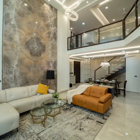 A double-height living room with a floor-to-ceiling book-matched marble feature wall