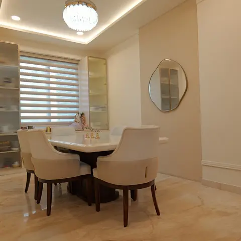 A formal dining room with a marble-top table on a dark wood base, cream upholstered chairs