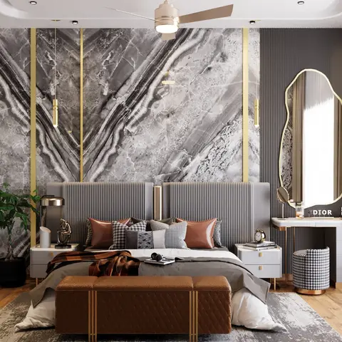 A grey channel-tufted headboard sits beneath a dramatic book-matched marble feature wall with brass trim