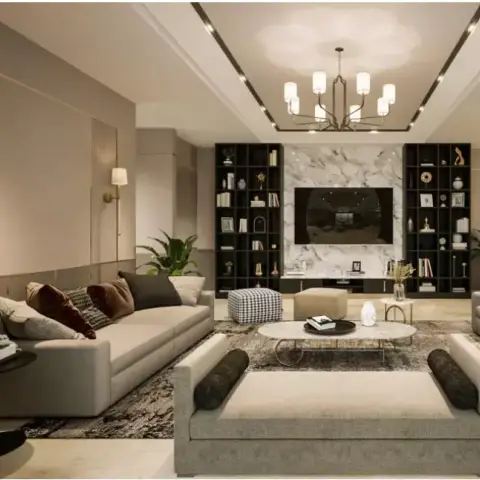 A large living room where an L-shaped ivory sofa and a grey bolster-ended daybed face a book-matched white marble TV wall flanked by two full-height black open