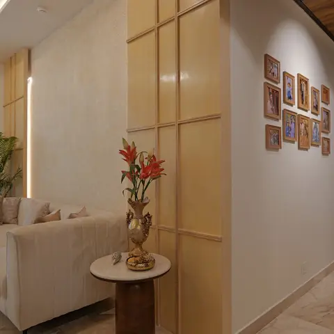 A living room corner with a grid-paneled wood pillar beside a gallery wall of family photo frames