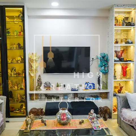 A living room TV unit flanked by two tall backlit glass curio cabinets densely packed with figurines and collectibles.