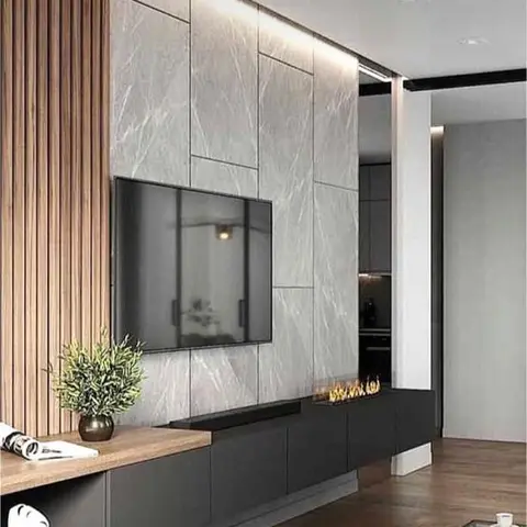 A living room TV wall combining backlit grey marble-look stone panels with fluted wood slat cladding