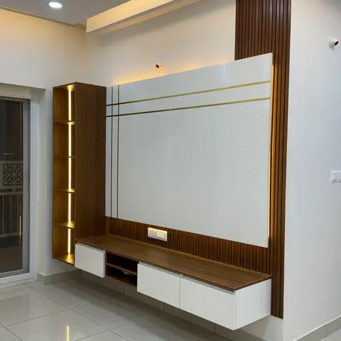 A living-room TV wall with fluted wood panelling, a white ribbed feature panel inlaid with brass strips