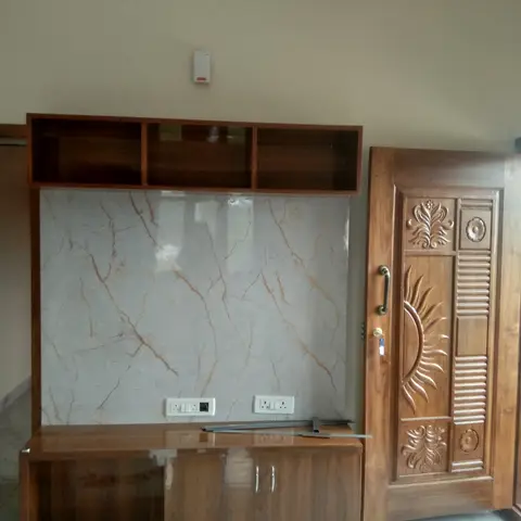 A living-room TV wall with a veined marble slab backdrop and a walnut floating console