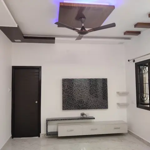 A living room with a black-and-white crackled-pattern TV feature wall, a floating storage console below