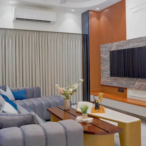 A living room with a book-matched stone-slab TV feature wall flanked by fluted amber wood panelling, a floating wood-and-white console