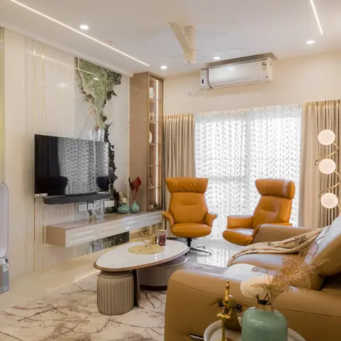 A living room with a fluted cream panel wall and stone-effect TV backdrop, mustard leather recliner armchairs and an oval marble-top coffee table