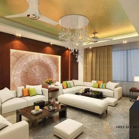 A living room with a gold-toned cove ceiling, a large carved circular wood wall panel, cream sofas with citrus-colored cushions