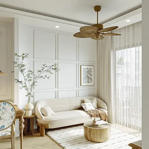 A living room with a white grid-moulding wall, a curved cream boucle sofa, a round raw-wood stump coffee table, a rattan-blade ceiling fan