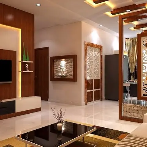 A living room with a wood-panelled cove-lit TV wall and a CNC-cut jaali screen hanging as a room divider under a coffered wood-strip ceiling