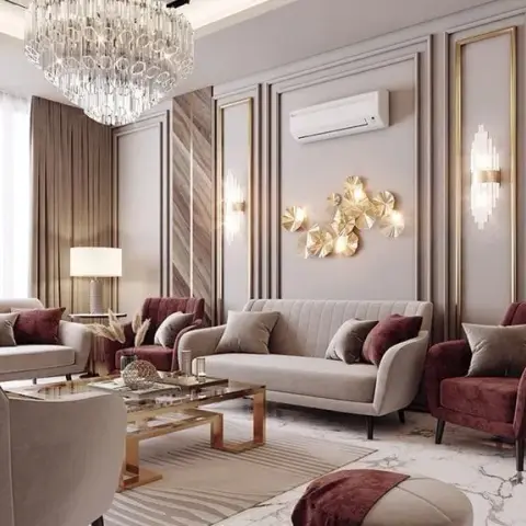 A living room with gold-trimmed wall panelling, a tiered crystal chandelier, a gold leaf sculptural wall installation