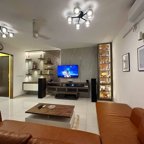 A living room with tan leather sofas facing a wood-and-glass TV console under a grey stone-clad wall