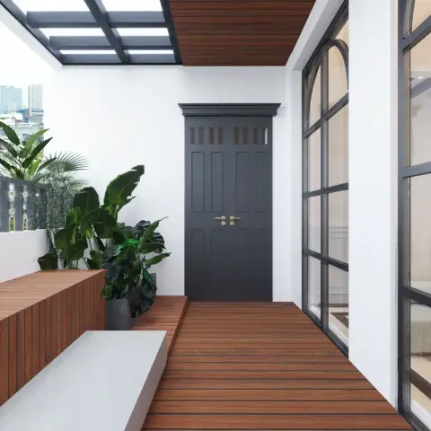 A long narrow balcony deck in warm hardwood running to a black panelled double door