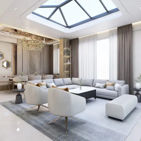A luxury living/dining space beneath a pyramid skylight, with a grey L-shaped sectional and swivel accent chairs around a marble coffee table
