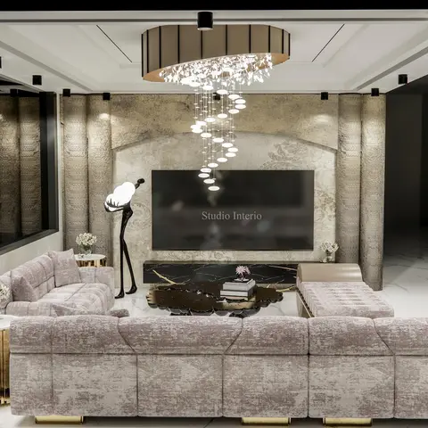 A luxury living room with a fluted stone-panelled TV wall under an arched niche, a cascading disc chandelier, a plush mauve sectional