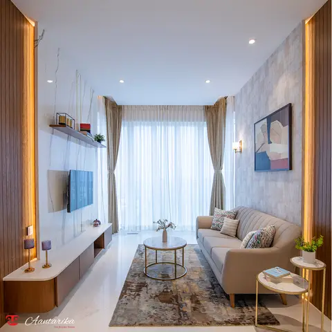 A narrow living room framed by backlit fluted wood side panels, with a channel-tufted beige sofa, a round marble-and-brass coffee table