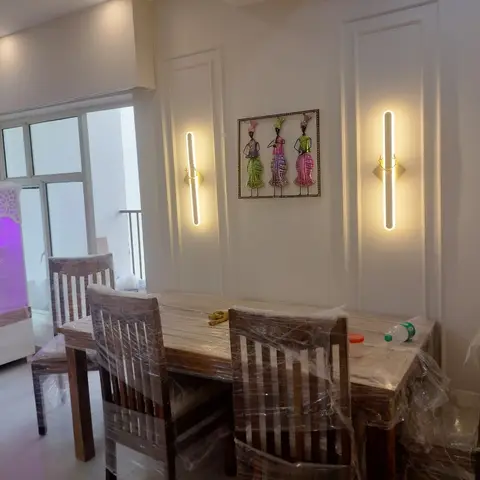 A newly furnished dining room with a solid-wood table and chairs still wrapped in protective plastic film