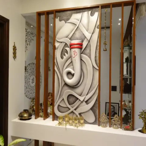 A pooja feature wall with a sculpted plaster Ganesha relief panel set within a wood slat partition