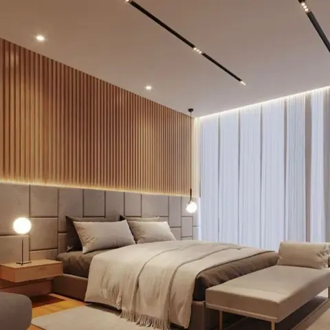 A primary bedroom with a fluted wood slat accent wall, a channel-tufted upholstered headboard, floor-to-ceiling sheer curtains