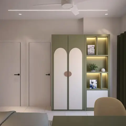 A sage-green wardrobe with two tall arched cream shutters and a pill-shaped rose handle