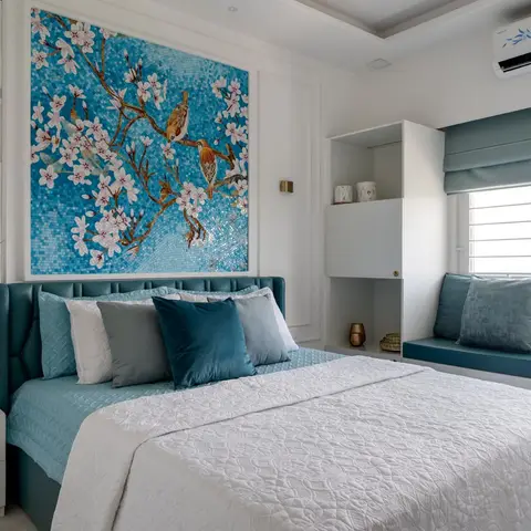 A teal tufted-leather upholstered bed beneath a large turquoise mosaic mural of blossoming branches and birds