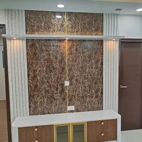 A TV feature wall in dark brown marble-effect stone cladding, flanked by fluted white-and-gold pilaster strips