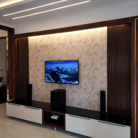 A TV wall with diagonal-pattern stone-look tile cladding flanked by fluted dark-wood panelling