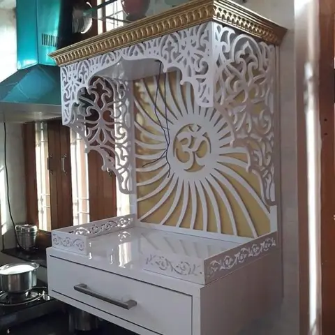 A wall-mounted pooja unit with an ornate white CNC-cut jaali screen framing an Om motif and a gold-painted cornice