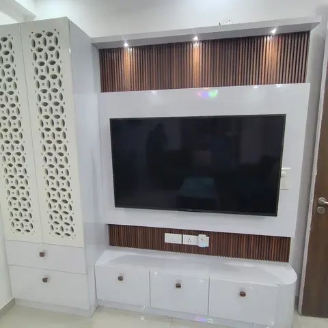 A white gloss TV feature wall with vertical wood-slat fluting above and below the screen