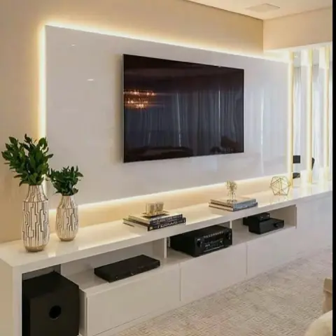 A white high-gloss TV panel floating off a cream wall with a warm LED halo running right around it