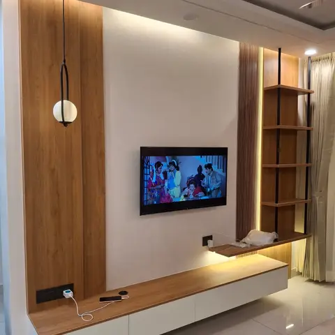 A wood-paneled TV wall with a floating two-tone console, a black-framed globe pendant light, and an open ladder-style corner shelf.