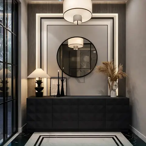 An entrance foyer with a black textured-front console table below a round mirror, a linen drum pendant light