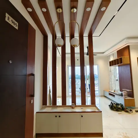 An entrance foyer with a dramatic wood-slat drop ceiling, two brass oval pendant lights, and a two-tone console/shoe cabinet beneath