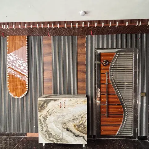 An entrance foyer with a fluted charcoal-and-wood wall panel, a marble-top shoe cabinet