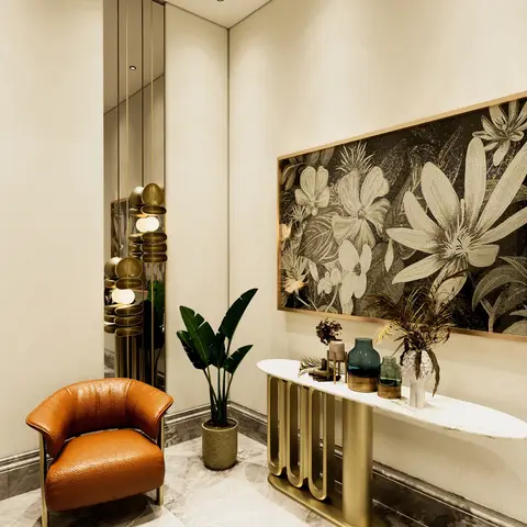 An entrance foyer with a gold wave-base marble console table styled with vases, a large floral mosaic wall art panel and an orange leather accent chair.