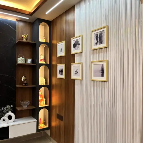 An entry passage with a black-marble-backed curio display niche of decor figurines beside a fluted-panelled wall hung with a symmetric black-and-white