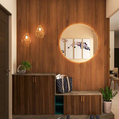 An entryway with a fluted wood-slat feature wall centred on a backlit circular niche framing three botanical art panels