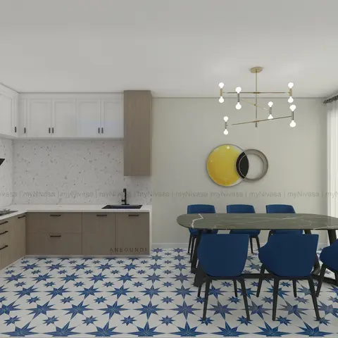 An open kitchen and dining space with a green marble oval table and navy chairs on a bold star-patterned tile floor, lit by a brass sputnik chandelier.